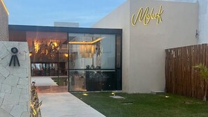 Ein modernes Gebäude mit Glasfassade und einem Neonlichtschild mit der Aufschrift 'Mok'.