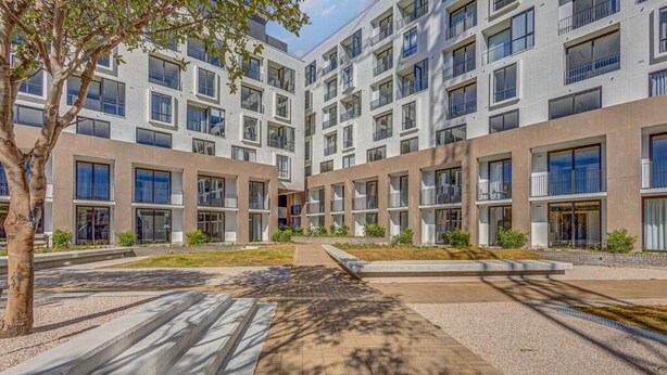 A modern multi-story building with a courtyard.