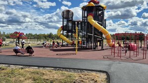 Un parque infantil con diversas estructuras de juego, incluyendo toboganes y zonas de escalada.