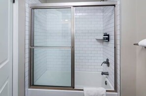 Een douche, handdoeken, zeep, toiletpapier