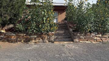 Un edificio con un muro de piedra y un camino de grava que lleva a una escalera.