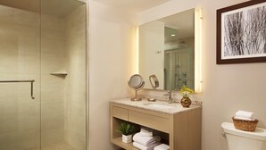 A modern bathroom with a glass shower enclosure, a vanity with a mirror, and a toilet. - Ocean Enclave, a Hilton Grand Vacations Club. (Myrtle Beach)