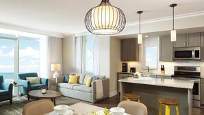 A modern hotel room with a living area, dining space, and kitchenette. - Ocean Enclave, a Hilton Grand Vacations Club. (Myrtle Beach)