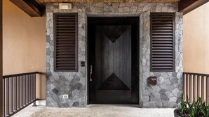 A stone facade with a dark door, a potted plant, and a sign indicating room number 10A.