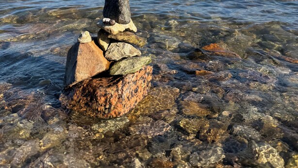 Un amas de rochers au bord d’une étendue d’eau claire.