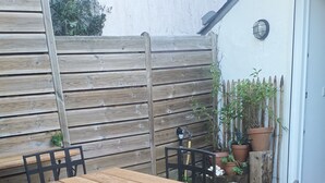 Une terrasse en bois avec une table et des chaises.