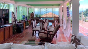A spacious indoor area with a pool table, comfortable seating, and a view of the outdoors. - VILLA NINA. Enjoy the most beautiful sunsets. (Manizales)