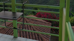 A terrace with a view of a sunset over a mountainous landscape. - VILLA NINA. Enjoy the most beautiful sunsets. (Manizales)