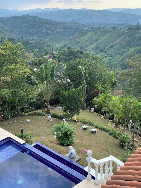Una piscina con vistas a exuberante vegetación y colinas lejanas.