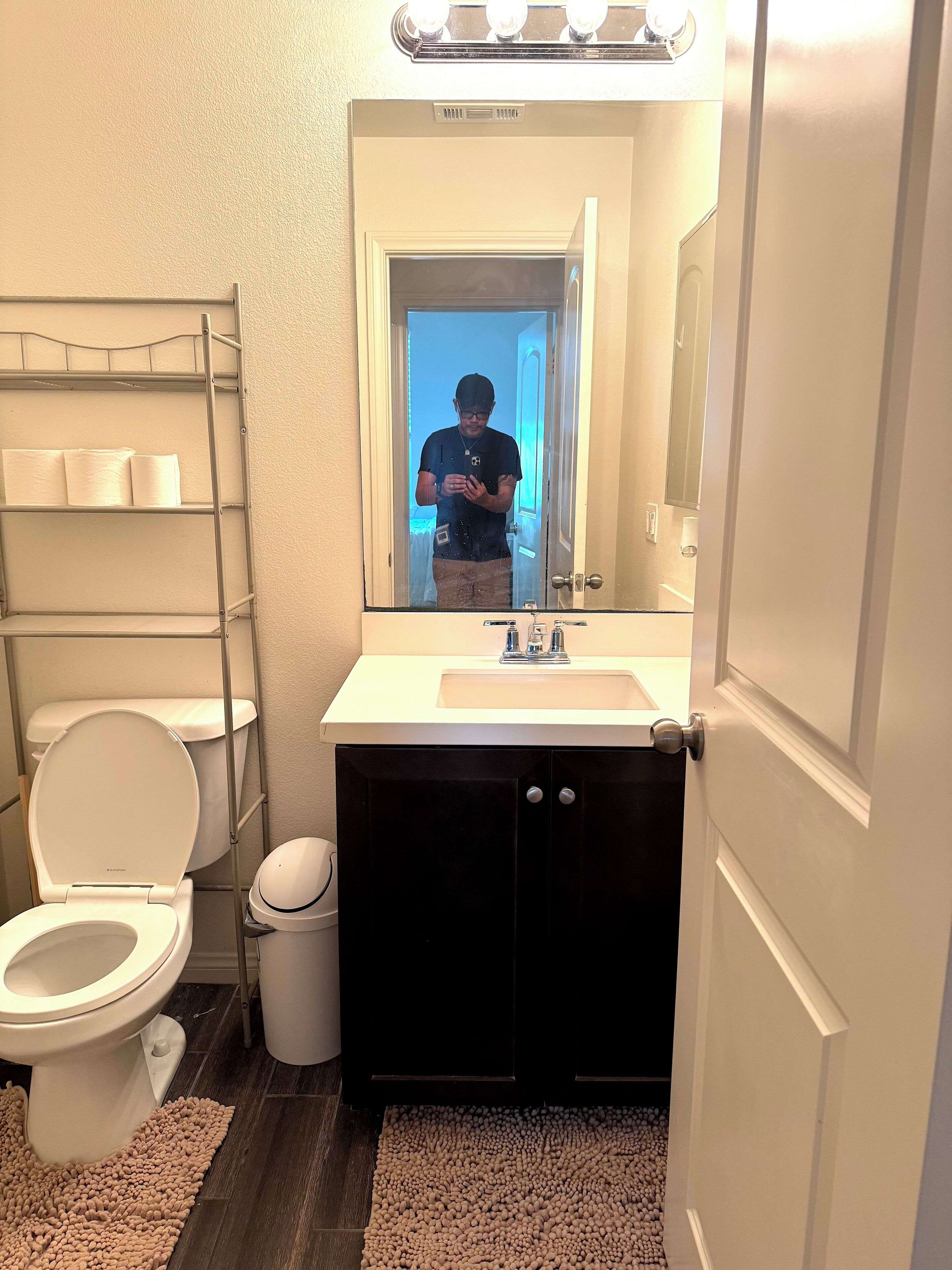 A bathroom with a toilet, sink, and mirror.