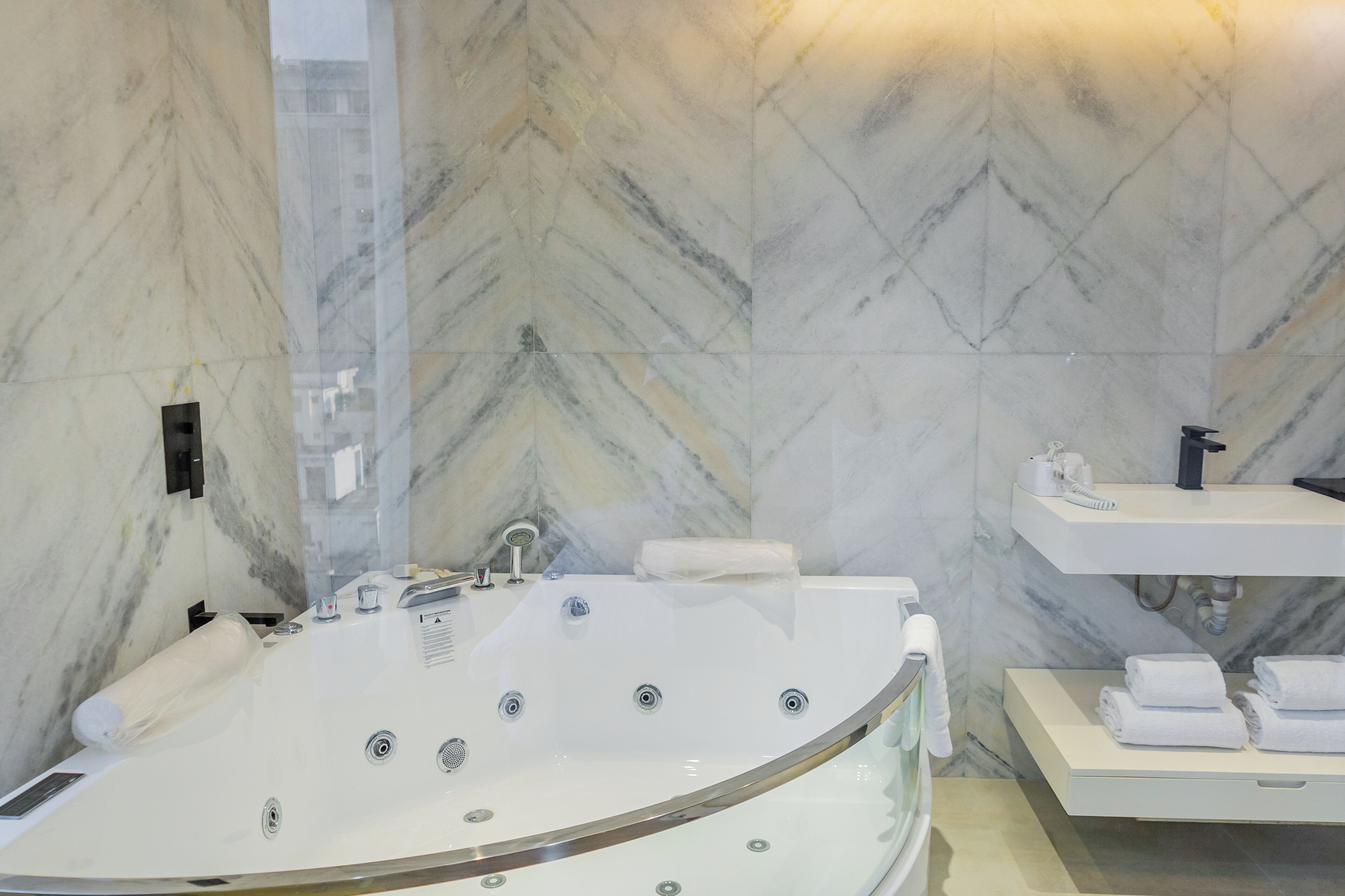 A modern bathroom with a freestanding bathtub, a vanity with a sink, and a towel rack.