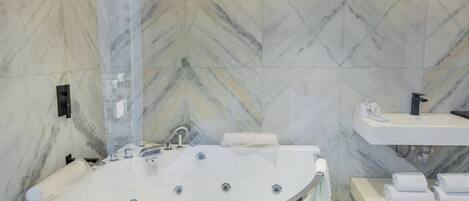 A modern bathroom with a freestanding bathtub, a vanity with a sink, and a towel rack.