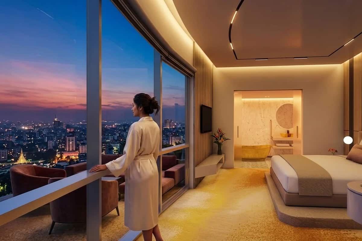Ein modernes Hotelzimmer mit großem Fenster, einem Bett, einer Sitzecke und einem Badezimmer.