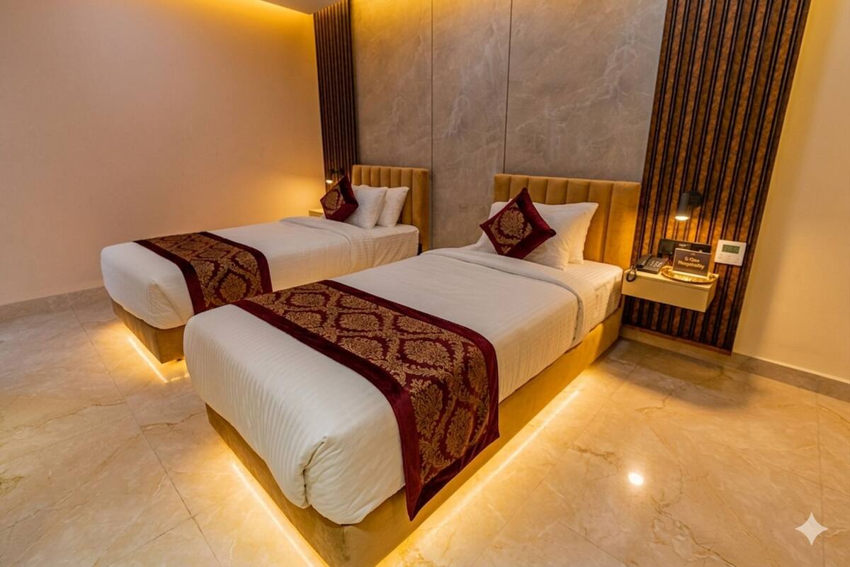 Ein Hotelzimmer mit zwei Betten, einem Nachttisch, einer an der Wand befestigten Uhr und einem Marmorboden.