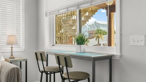 A room with a window, a desk, two chairs, a lamp, and a potted plant. - 18+ can book! Panama City Beach, Holiday Beach, The ole MTV house Neighborhood (Panama City Beach)