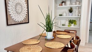 A dining area with a wooden table, woven placemats, and matching chairs. - SPRING HAVEN RETREAT! A BEUTIFULL ANDSPOTLESS!! (Newberry)