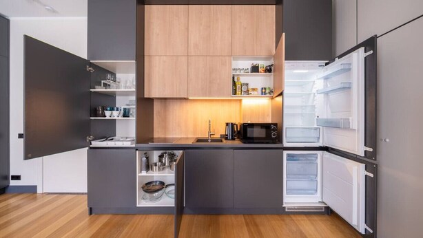 A modern kitchen with built-in appliances, wooden cabinets, and a central island.