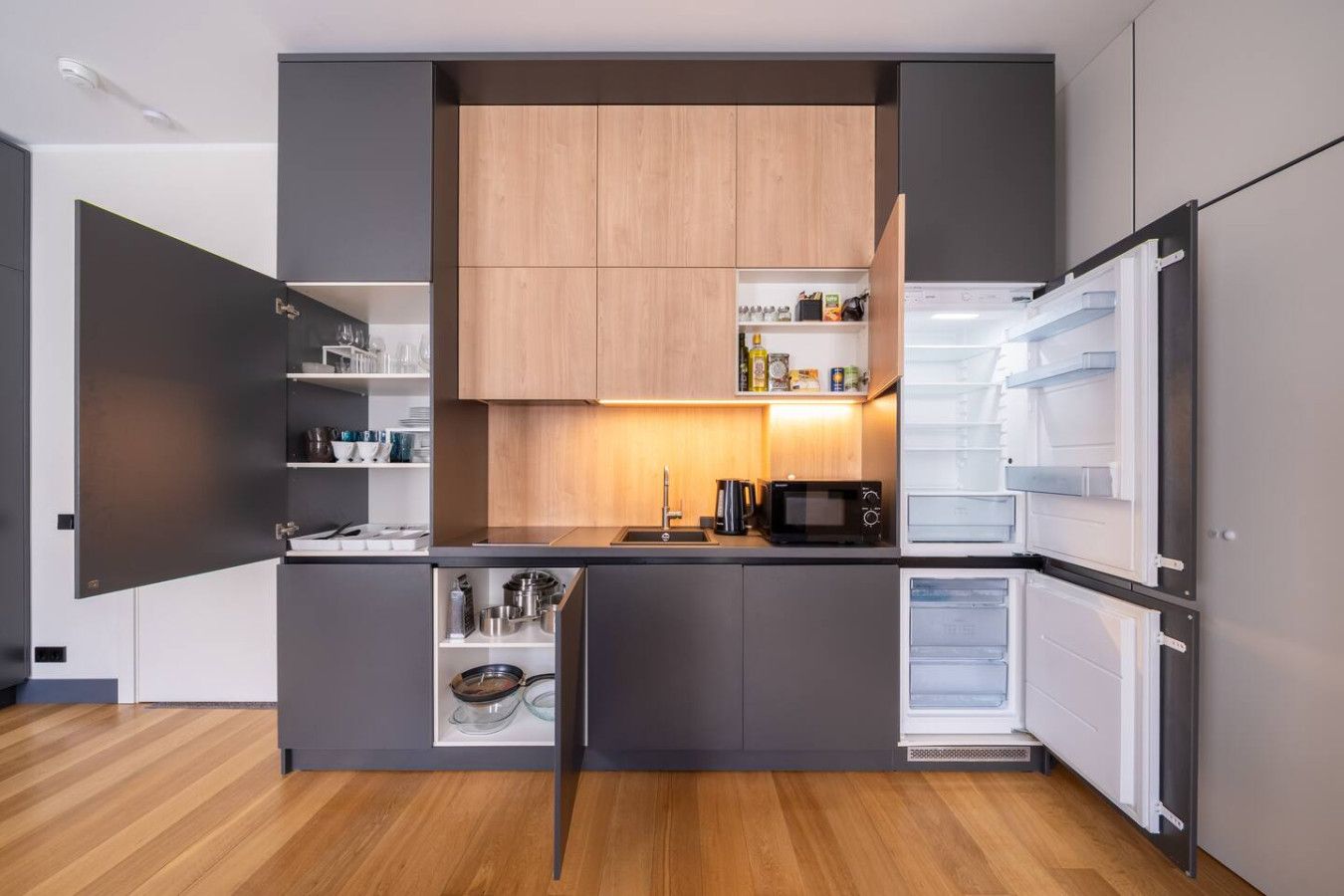 A modern kitchen with built-in appliances, wooden cabinets, and a central island.
