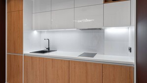 Une cuisine moderne avec un plan de travail blanc, un robinet noir et des armoires en bois.