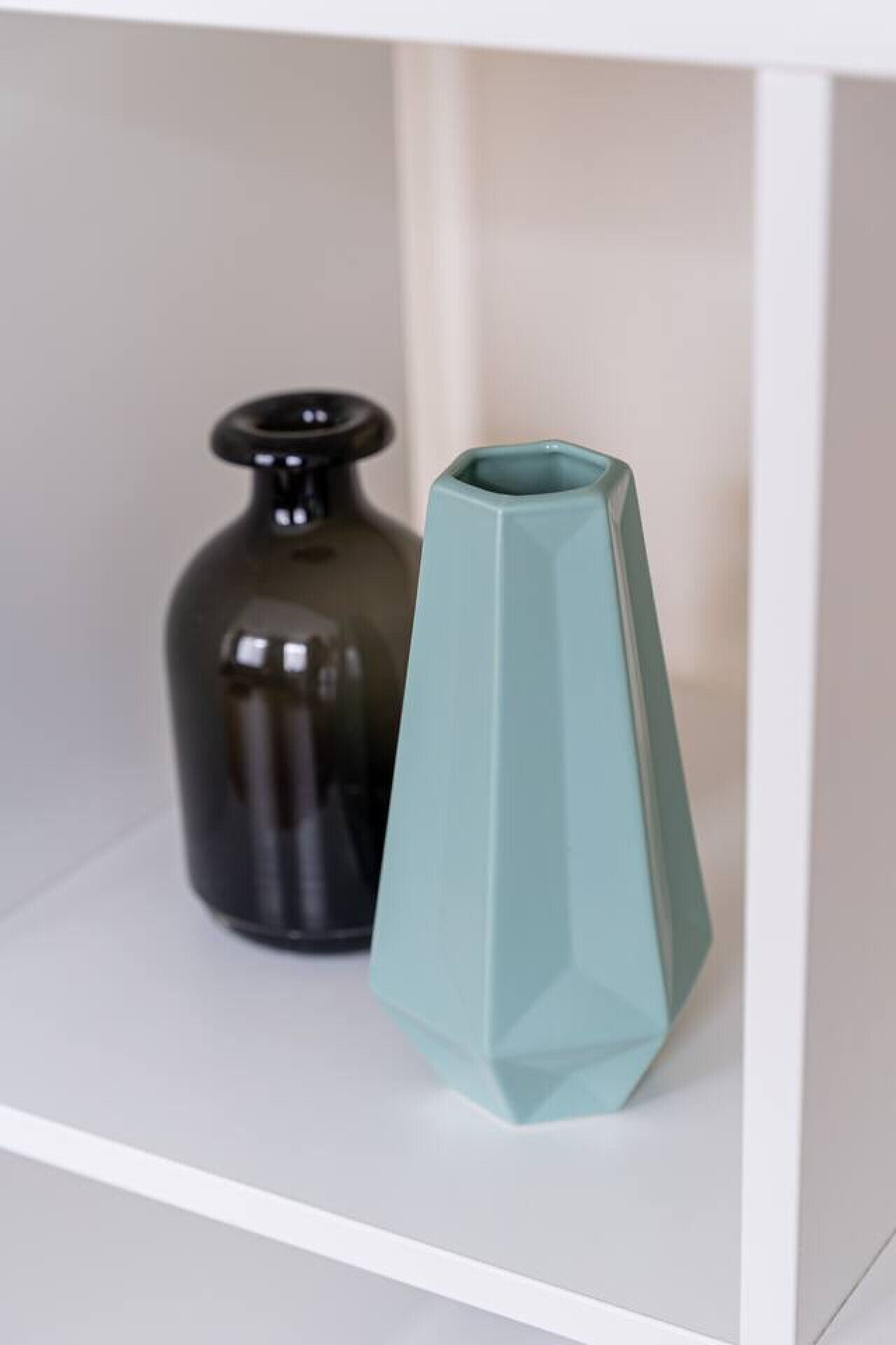 Two vases on a white shelf.