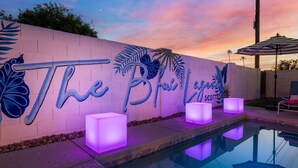 A poolside area with a sign reading "The Blue Lagoon Scottsdale" and illuminated cube-shaped lights.