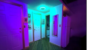 Un pasillo con puertas a ambos lados, una lámpara en el techo y una puerta con espejo.