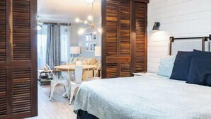 A bedroom with a bed, a ceiling fan, and wooden paneling. - Charming condo walking distance to Sapphire Beach, St Thomas (St Thomas)