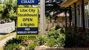 Placa de motel com check-in 24 horas e um restaurante Golden Chain.