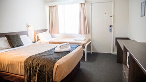 A hotel room with two beds, a desk, and a door. - Lilac City Motor Inn Standard Twin Room 20 (Goulburn)