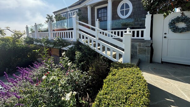 A house with a white front porch, a stone facade, and a circular window.
