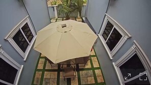 A dining area with a table and chairs, surrounded by four windows. - Spacious 2BR private apartment setting for families near Accra. (Oyibi)