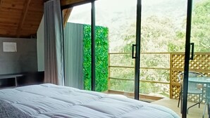 A bedroom with a large bed, a window with a view of greenery, and a balcony with a table and chairs. - Hotel Noral Lemont (Copacabana)