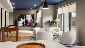 A modern living room with a pool table, comfortable seating, a large abstract painting, and a view through large windows. - Luxury Apartments by Hyatus White Plains (White Plains)