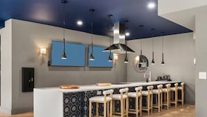 A modern kitchen with a central island, bar stools, pendant lighting, and a patterned backsplash. - Luxury Apartments by Hyatus White Plains (White Plains)