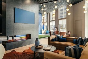 A modern lobby with a fireplace, comfortable seating, and large windows. - Luxury Apartments by Hyatus White Plains (White Plains)