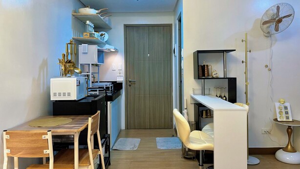 A compact kitchen with a dining area, a small table, and a chair.