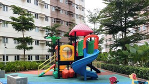 A playground with a slide, climbing structures, and a merry-go-round.