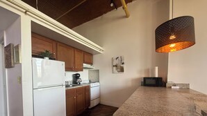 A kitchen with wooden cabinets, a white refrigerator, a stove, and a granite countertop. - Downtown: The Belle Isle View Loft (Detroit)