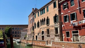 A canal with buildings on one side and a boat docked on the other.