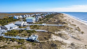 A coastal area with buildings, a beach, and a boardwalk.