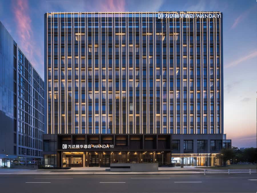A modern hotel with a grid of windows and a prominent sign at the top.