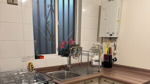 Eine Küche mit Gasherd, Spüle und einem Fenster mit Jalousien.