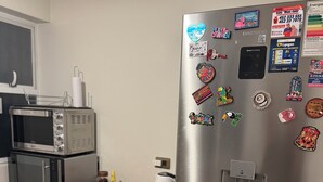Eine Küche mit einem Edelstahl-Kühlschrank, einer Mikrowelle und einem Toaster auf der Arbeitsfläche.