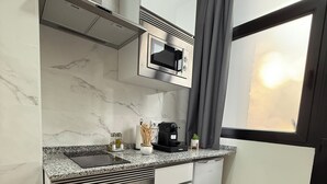 A modern kitchen with a built-in microwave, oven, and coffee maker.