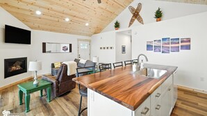 A modern kitchen with a wooden ceiling, a built-in island, and a large window. - Peaceful with views, brand new, 2-bedroom, 2 bathroom house on Finger Lake. (Palmer)