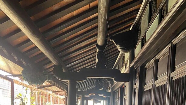 A corridor with a tiled floor, wooden columns, and a railing. - Phuong Maison d'Art (Hanoi)