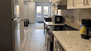 A modern kitchen with a refrigerator, microwave, stove, and coffee maker. - Whitby Hideout - 3BR 5BD 3WR Pool Table Sauna close to Thermea SPA (Whitby)