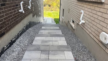 Um caminho que leva a um edifício com fachada de tijolos e uma janela.