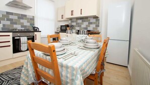Una cucina funzionale con mobili bianchi, un fornello e un frigorifero.