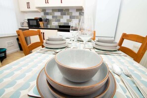 A dining table set with plates, bowls, glasses, and cutlery. - Cosy 2BR Flat Near Anfield & Goodison, Liverpool (Liverpool)